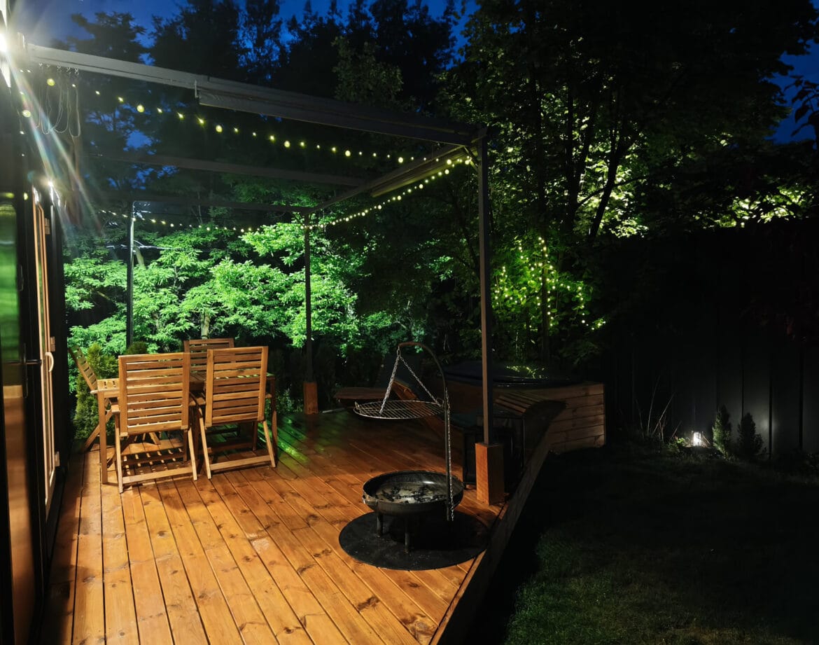 Oświetlony taras domku nad Wisłą z balią nocą