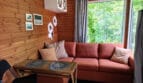 Wnętrze domku nad Wisłą z sofą i dużym oknem z widokiem na zieleń