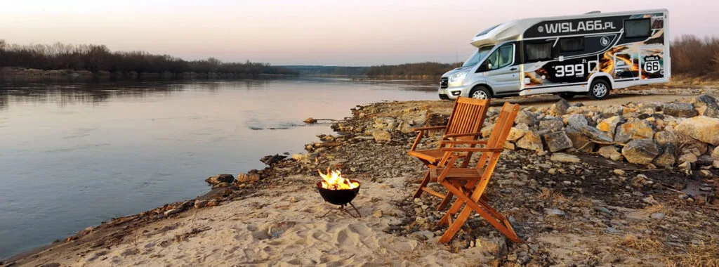 kamper i krzesła na plaży nad zbiornikiem wodnym