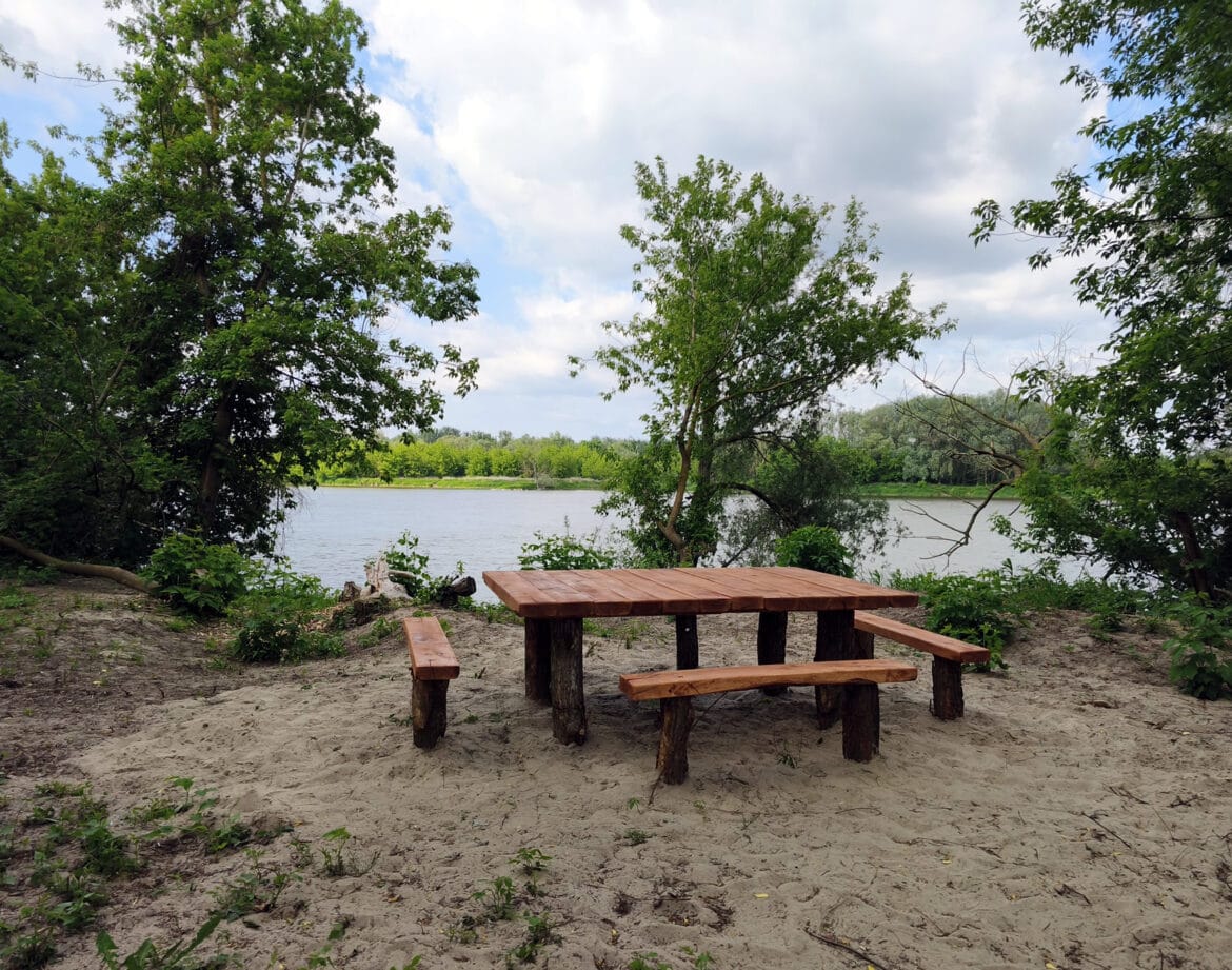 Drewniany stół piknikowy nad Wisłą w otoczeniu zieleni