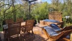 Drewniany taras z jacuzzi, leżakami i widokiem na zieleń nad Wisłą