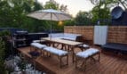 Taras domku Wisła66 z jacuzzi, grillem gazowym, dużym stołem i strefą wypoczynkową w otoczeniu zieleni